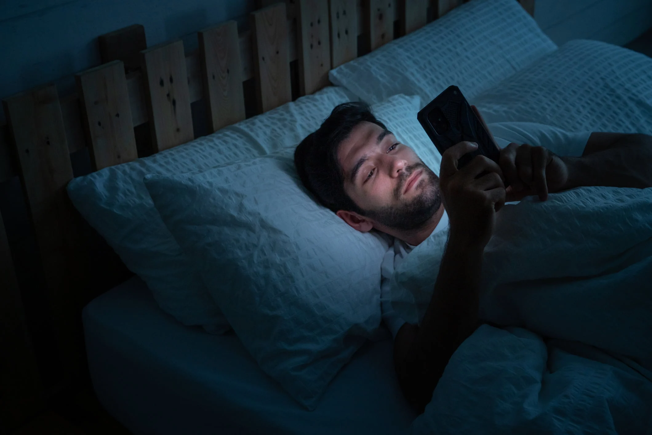 Doomscrolling Malaysia — woman anxiously scrolling her phone in bed at night